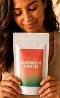 A woman holding a white stand-up pouch of ceremonial matcha with a coral-to-green gradient label. The pouch reads HOTEA CEREMONIAL MATCHA' and 'from JAPAN